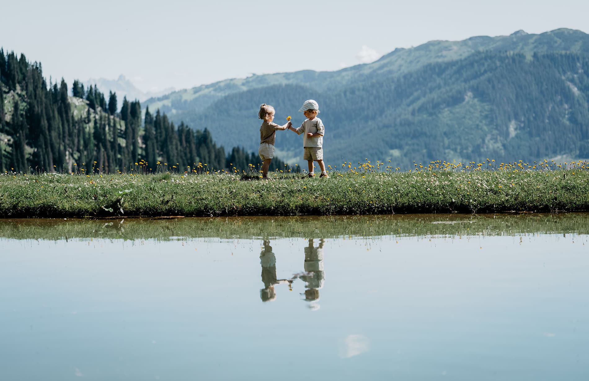 Kinder spielen auf der Almwiese am Bergsee